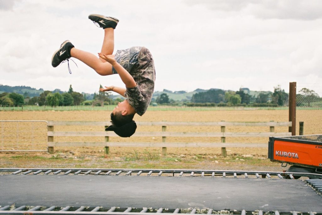 A boy jumps on a trampoline