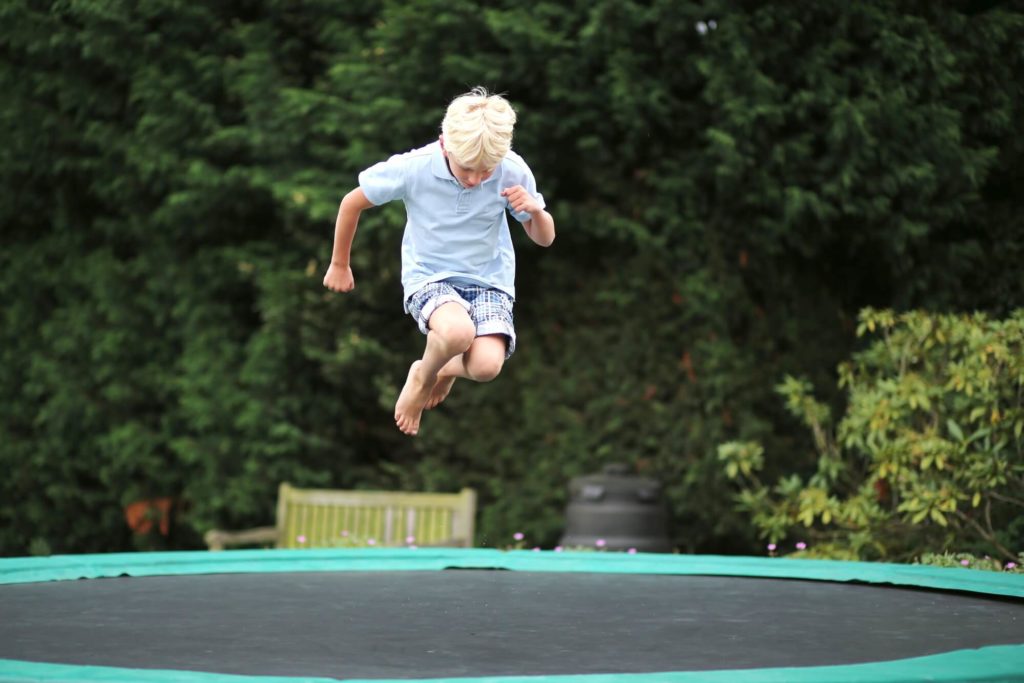 Boy jumping high in the sky on trampoline