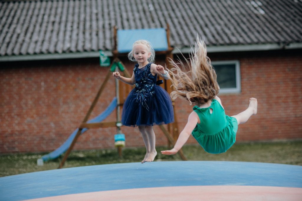 Girl in Blue Dress Playing on Blue Trampoline 1