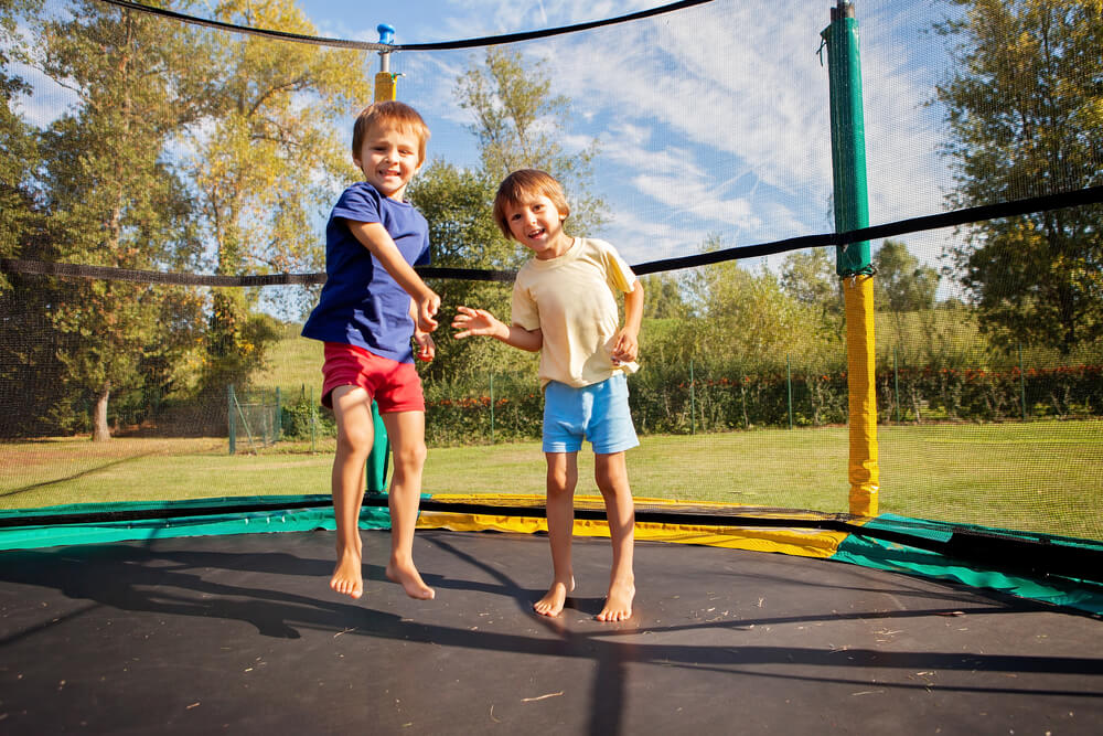 Two sweet kids, brothers, jumping on a trampoline