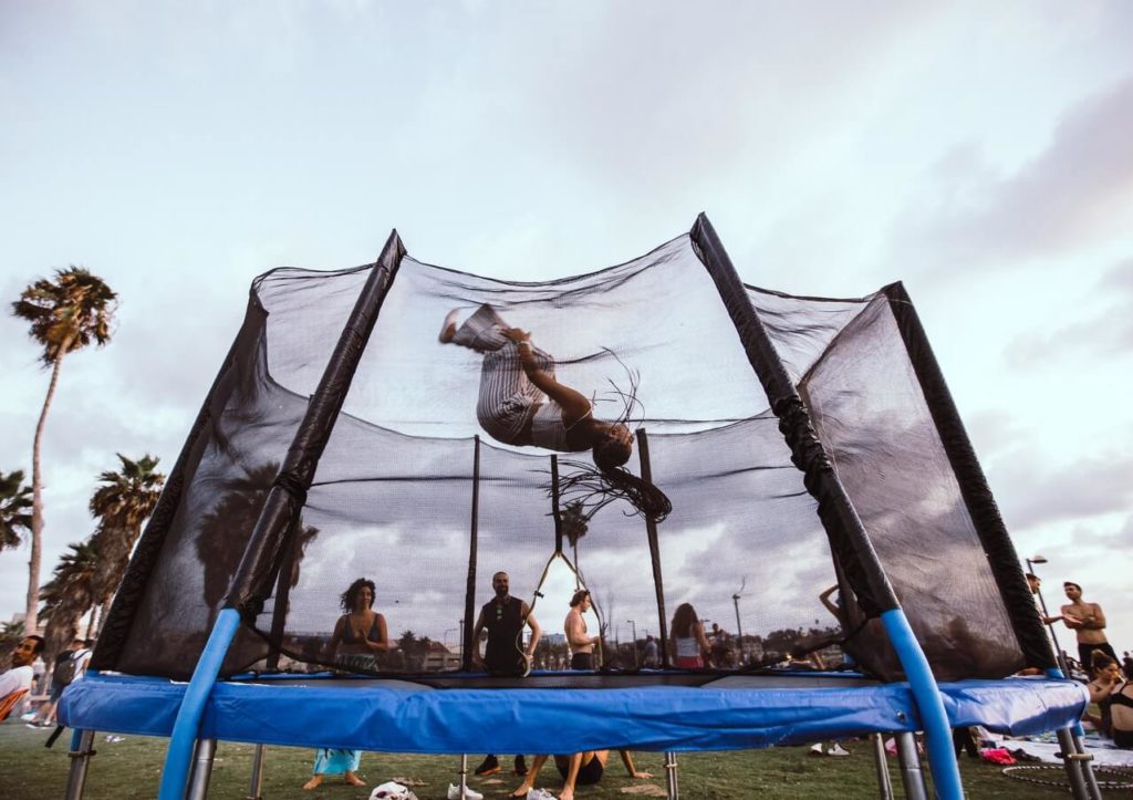 Unrecognizable jumper doing somersault on trampoline